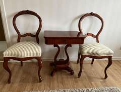 två antika stolar med bord