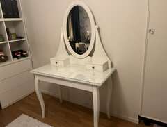 Sminkbord med spegel och pall.