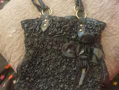 svart skinnväska med blomma
