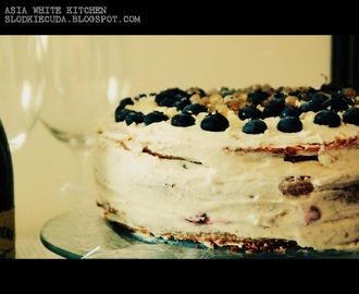 Tort z kremem mascarpone, brzoskwiniowo -winną konfiturą, i posypką z białej czekolady i krówek