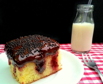 Poke cake de baunilha com geleia de frutas vermelhas e cobertura de chocolate amargo