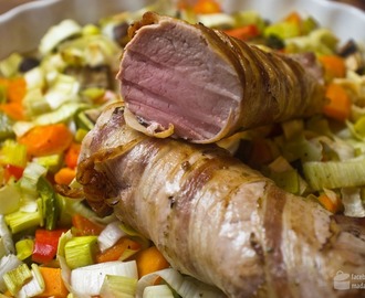 Im Ofen gegartes Schweinefilet im Speckmantel auf Gemüsebett