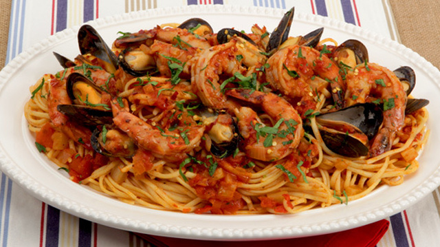 Seafood Linguine
	            
olive oil
onion
diced fennel bulb
cloves garlic
bay leaves
salt
whole tomatoes
dry white wine
tomato paste
paprika
dried Italian herb seasoning
hot pepper flakes
mussels
large shrimp
linguine
minced fresh parsley