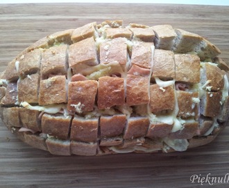 Chleb nacinany z serem, szynką i i masłem czosnkowym