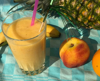 Tropische smoothie met ananas, banaan, perzik en sinaasappel