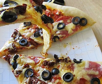 Pizza na cienkim cieście z suszonymi pomidorami i oliwkami