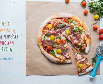 Pizza z mozzarellą, szynką, pomidorami i rukolą