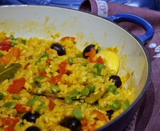 Vegetable paella with bell peppers, broad beans and black olives