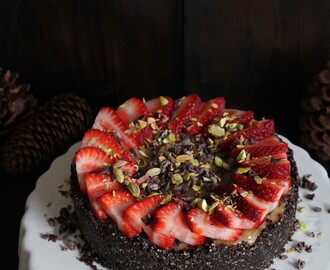vanilla cheesecake with chocolate crust, strawberries, cacao nibs + pistachios