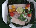 Salmon in coconut and tomato sauce in banana leaf