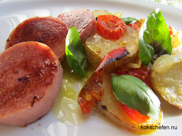 Medhelhavsinspirerad falukorv serverat med en ugnsstekt potatis med tomat, paprika och lök