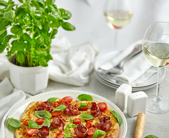 Pizza Italiano- z pomidorami i bazylią, mozzarellą oraz kwiatami z szynki parmeńskiej na kremowym sosie