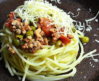 Makaron spaghetti z sosem pomidorowym, zielonym groszkiem i mieloną karkówką