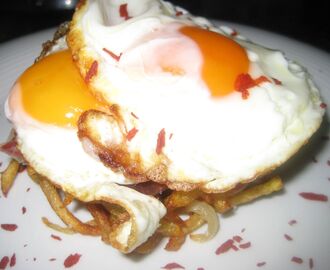 Huevos trufados fritos, con patatas, cebolla y polvo de tomate