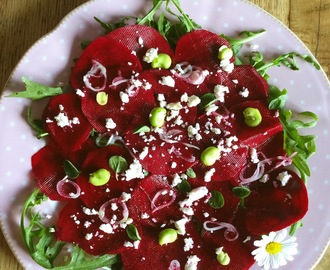 Carpaccio di rape rosse marinate agli agrumi con scalogno, fave fresche e feta greca