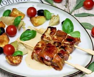 Italiaanse varkenshaasspiesjes met parmaham en salie geserveerd met een romige wittewijnsaus