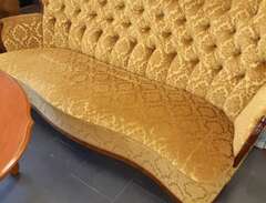 Gullig gammal soffa med bord