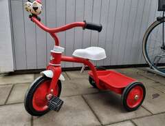 Röd trehjuling i plåt