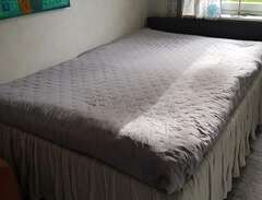 Mörk grå säng med sänggavel